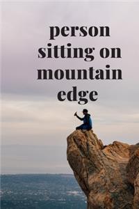 person sitting on mountain edge