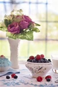 A Bowl of Fresh Berries and a Vase of Flowers on the Breakfast Table Journal