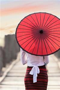 A Woman With a Red Parasol Walking on a Pier in Myanmar Journal
