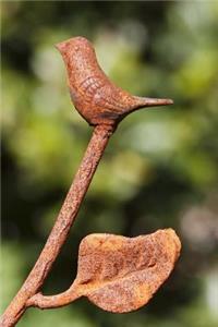 A Rustic Wrought Iron Bird and Leaf on a Fence Journal