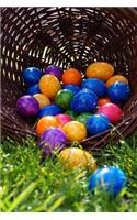 Basket Filled with Colorful Easter Eggs on the Grass Journal