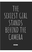 The Sexiest Girl stands behind the Camera Notebook