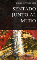 Sentado junto al muro